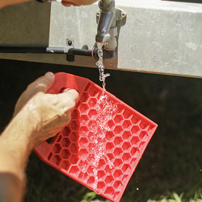 Redfoot Levelling - A man pouring water onto Redfoot Levelling 'Anti Ant' Stabiliser Pads.