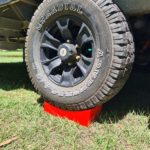 Redfoot Levelling - A truck with a tire on top of Redfoot Levelling Camper Levellers that utilizes motorhome stabilizer pads.