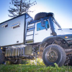 Redfoot Levelling - A white truck with an Expedition Off-Road Vehicles parked in the grass.