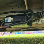 Redfoot Levelling - The underside of a vehicle with a battery attached to it equipped with the Redfoot Levelling Renault ‘AutoLift’ System.